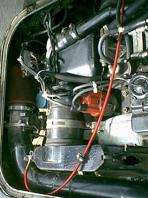 Intake on the left; bike-style cable and red housing for throttle cable